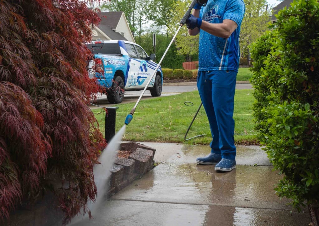 A to Z Power Washing technician pressure washing a concrete walkway